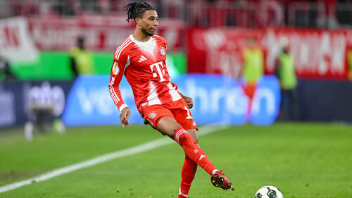 Michael Olise im Trikot des FC Bayern München fokussiert auf dem Spielfeld