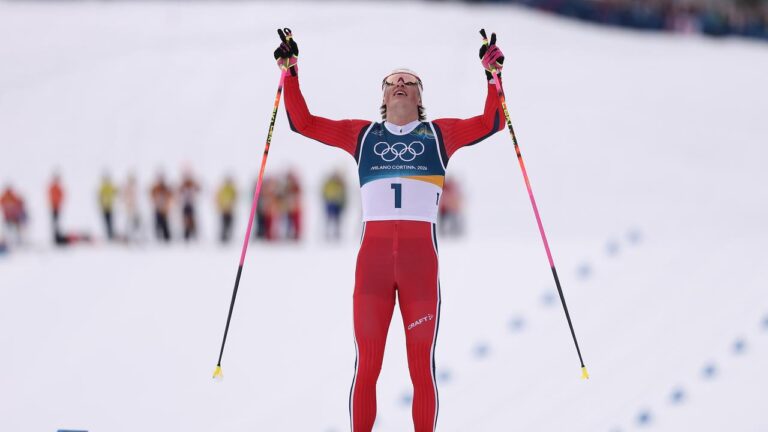 Johannes Klaebo jubelt mit Goldmedaille im Zielbereich des Langlauf-Stadions