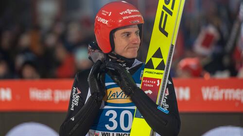 Karl Geiger im Auslauf der Skisprungschanze mit enttäuschtem Gesichtsausdruck