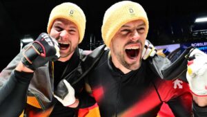 Johannes Lochner und Georg Fleischhauer jubeln im Zielbereich über den Olympiasieg im Zweierbob