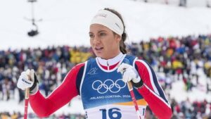 Kristine Stavas Skistad enttäuscht im Zielraum nach dem olympischen Sprint, während im Hintergrund schwedische Athletinnen jubeln