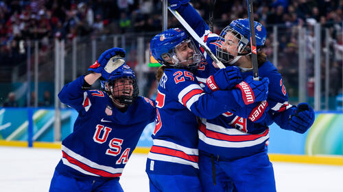 Jubelnde Eishockey-Spielerinnen der USA auf dem Eis nach dem Gold-Gewinn gegen Kanada