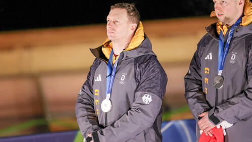 Johannes Lochner und Francesco Friedrich jubeln gemeinsam im Zielbereich der Bobbahn in Cortina d'Ampezzo
