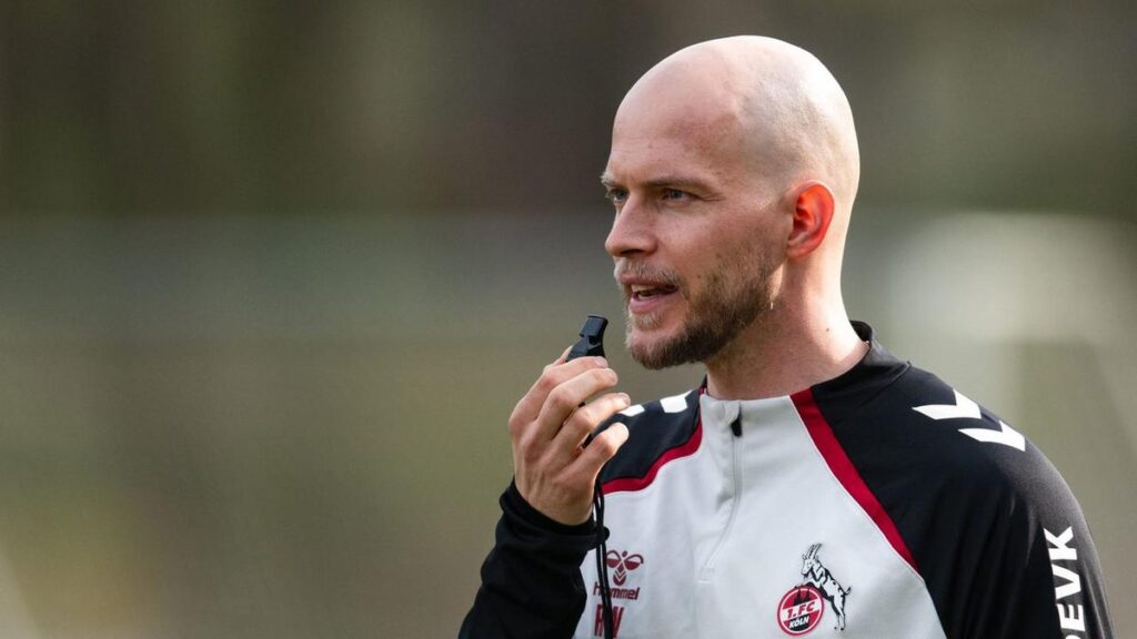 René Wagner, der neue Cheftrainer des 1. FC Köln, steht im Trainingsanzug nachdenklich auf dem Trainingsplatz.