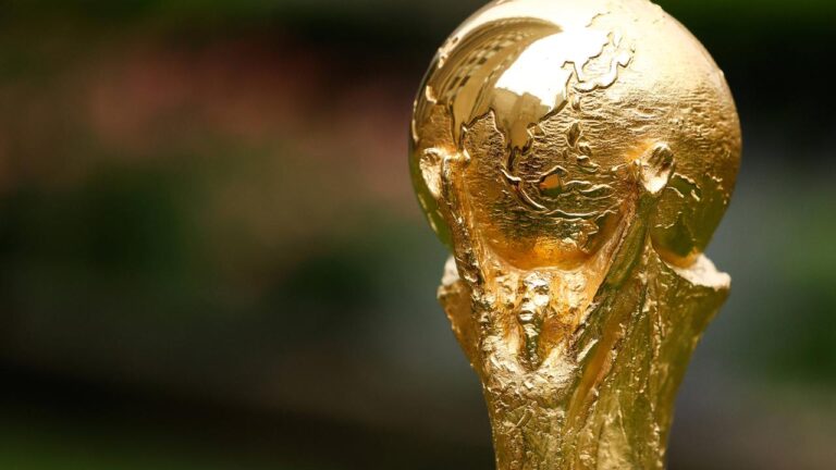 Jubelnde Spieler der deutschen Nationalmannschaft auf dem Rasen im weißen Trikot