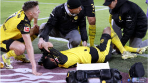 BVB-Kapitän Emre Can sitzt mit schmerzverzerrtem Gesicht auf dem Rasen und hält sich das linke Knie.