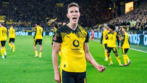 Nico Schlotterbeck im Trikot von Borussia Dortmund gestikuliert dirigierend auf dem Spielfeld