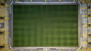 Zweikampf zwischen Spielern von Bayer Leverkusen und Bayern München vor vollbesetzten Rängen