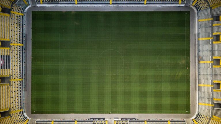 Zweikampf zwischen Spielern von Bayer Leverkusen und Bayern München vor vollbesetzten Rängen