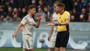 Joshua Kimmich im Trikot des FC Bayern München gestikuliert während eines Spiels auf dem Platz.
