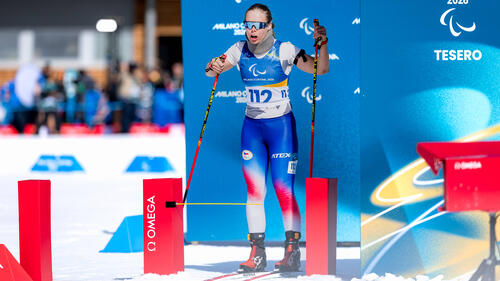 Para-Biathletin Carina Edlingerova mit ihrem Blindenhund im Schnee bei einem Wettkampf