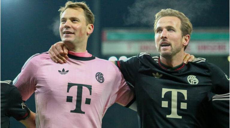 Manuel Neuer und Harry Kane klatschen sich im Trikot des FC Bayern München auf dem Spielfeld ab