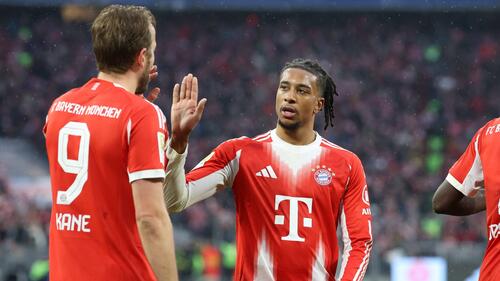 Michael Olise vom FC Bayern München bejubelt ein Tor auf dem Spielfeld in der Allianz Arena.