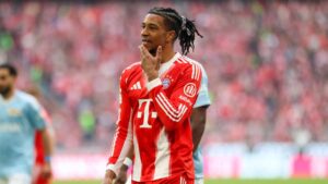 Michael Olise im Trikot des FC Bayern München bejubelt ein Tor auf dem Spielfeld.