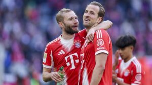 Uli Hoeneß und Harry Kane lächeln gemeinsam im Stadion des FC Bayern München