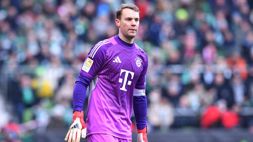 Manuel Neuer im Torwart-Trikot des FC Bayern München blickt nachdenklich auf das Spielfeld