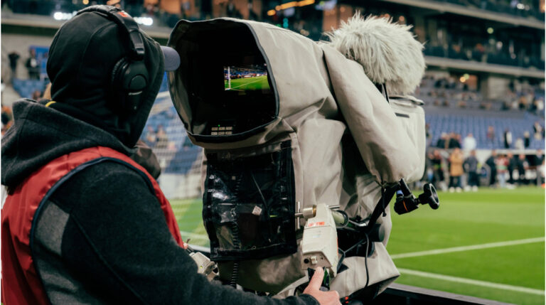 Das Logo der FIFA und YouTube nebeneinander vor einem Fußballfeld, symbolisch für die Übertragung der Weltmeisterschaft.