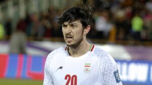 Sardar Azmoun im Trikot der iranischen Nationalmannschaft mit ernstem Blick auf dem Spielfeld