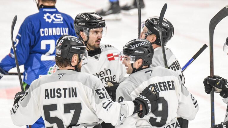 Eishockey-Spieler der Kölner Haie und Straubing Tigers im packenden Zweikampf auf dem Eis