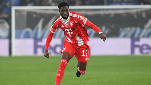 Alphonso Davies im roten Trikot des FC Bayern München am Ball
