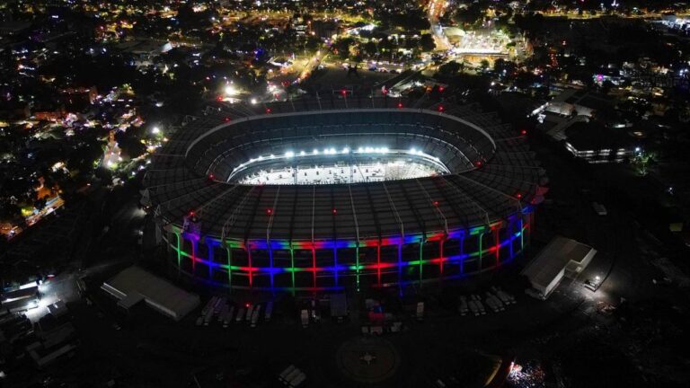 Mexikanische Fußballfans in grünen Trikots jubeln mit Fahnen auf der Tribüne