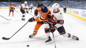 Symbolbild: Eishockey-Puck auf dem Eis vor unscharfem NHL-Hintergrund, passend zur Ankündigung der Spiele in Düsseldorf