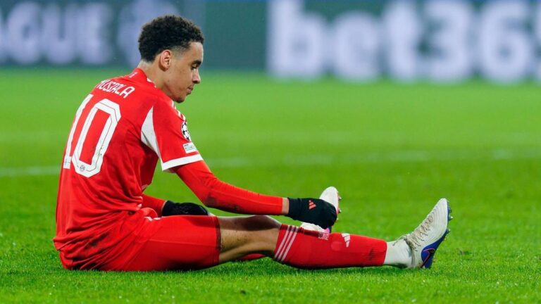 Bundestrainer Julian Nagelsmann blickt ernst, während der verletzte Jamal Musiala im Bayern-Trikot auf dem Boden sitzt.