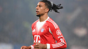 Michael Olise im Trikot des FC Bayern München am Ball auf dem Spielfeld
