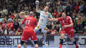 Felix Claar vom SC Magdeburg beim Sprungwurf gegen die Abwehr der MT Melsungen