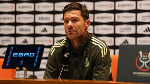 Trainer Xabi Alonso im Anzug an der Seitenlinie mit nachdenklichem Blick