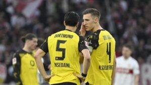BVB-Trainer Niko Kovac schaut nachdenklich, während Ramy Bensebaini im Trikot von Borussia Dortmund am Ball ist.