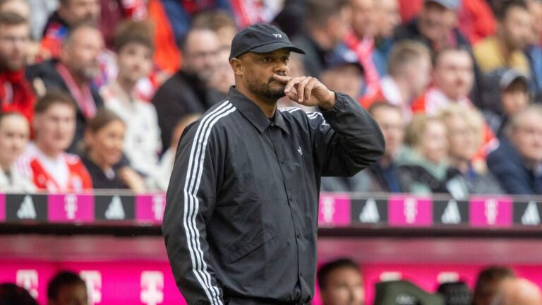 Die Trophäe des DFB-Pokals steht beleuchtet auf dem Rasen in einem Fußballstadion