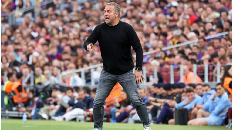 Hansi Flick steht im Anzug am Spielfeldrand und gibt Anweisungen während eines Spiels des FC Barcelona.