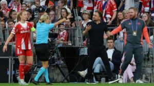 Enttäuschte Spielerin des FC Bayern München neben einer Schiedsrichterin in der Women's Champions League gegen Barcelona