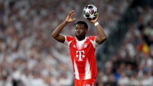 Alphonso Davies im Trikot des FC Bayern München mit nachdenklichem Blick auf dem Spielfeld