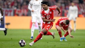 Serge Gnabry im Trikot des FC Bayern München fasst sich mit schmerzverzerrtem Gesicht an den Oberschenkel