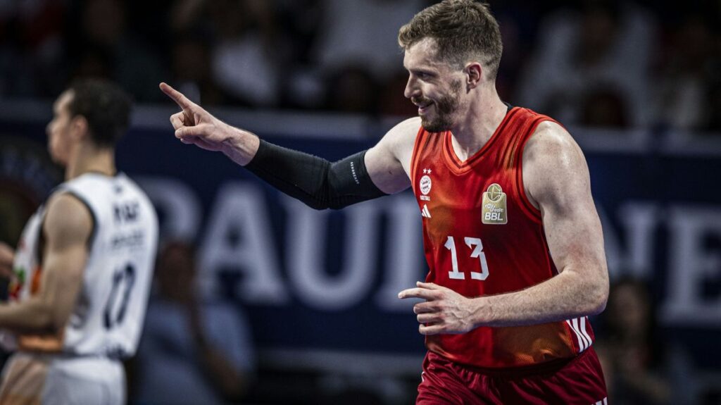 Basketball-Spieler des FC Bayern München und Alba Berlin kämpfen in einem intensiven Duell unter dem Korb um den Ball.