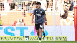 Can Uzun im Trikot von Eintracht Frankfurt blickt nachdenklich auf das Spielfeld