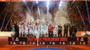 Max Darj und die Spieler der Füchse Berlin jubeln mit dem silbernen DHB-Pokal.