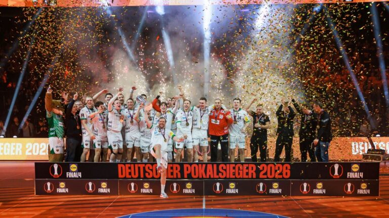 Max Darj und die Spieler der Füchse Berlin jubeln mit dem silbernen DHB-Pokal.