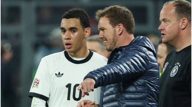 Jamal Musiala im Trikot der deutschen Nationalmannschaft im Gespräch mit Bundestrainer Julian Nagelsmann