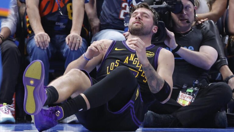 Luka Doncic sitzt mit schmerzverzerrtem Gesicht auf dem Hallenboden und hält sich den linken Oberschenkel