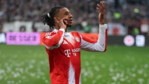 Michael Olise im Trikot des FC Bayern München und Luis Figo vor einem Champions-League-Hintergrund