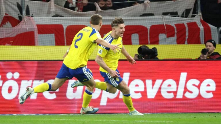 Robert Lewandowski winkt mit der Kapitänsbinde ins Publikum, schwedische Spieler jubeln im Hintergrund