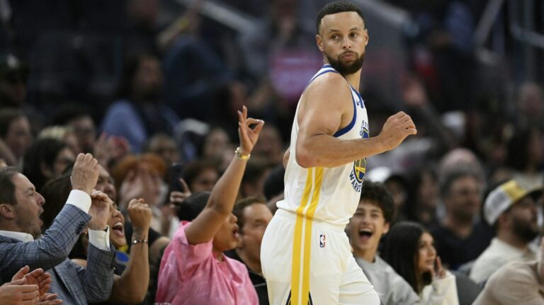 Stephen Curry im Trikot der Golden State Warriors dribbelt beim NBA-Spiel konzentriert mit dem Basketball.