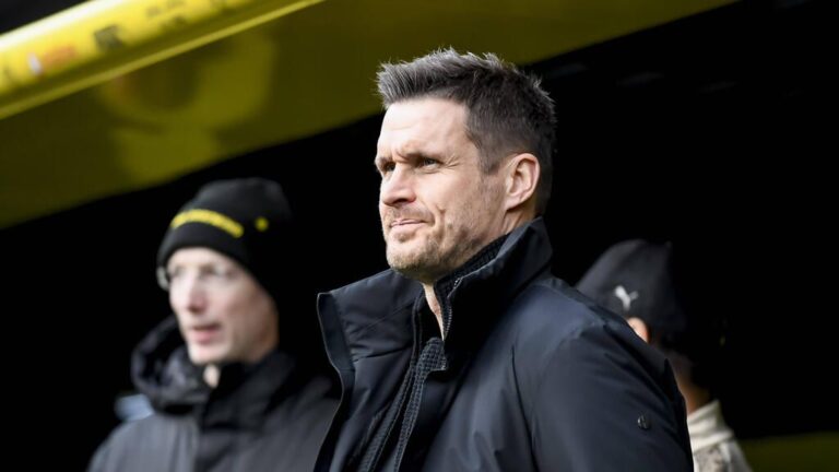 Sebastian Kehl im Anzug mit ernstem Blick am Spielfeldrand