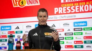 Marie-Louise Eta im Trainingsanzug von Union Berlin auf einer Pressekonferenz