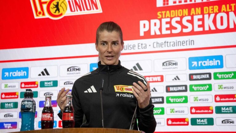 Marie-Louise Eta im Trainingsanzug von Union Berlin auf einer Pressekonferenz
