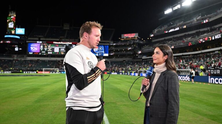 Spieler der deutschen Nationalmannschaft klatschen nach einem Spiel auf dem Rasen ab