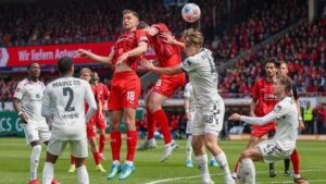 Trainer Frank Schmidt und enttäuschte Spieler des 1. FC Heidenheim nach dem Abstieg auf dem Rasen